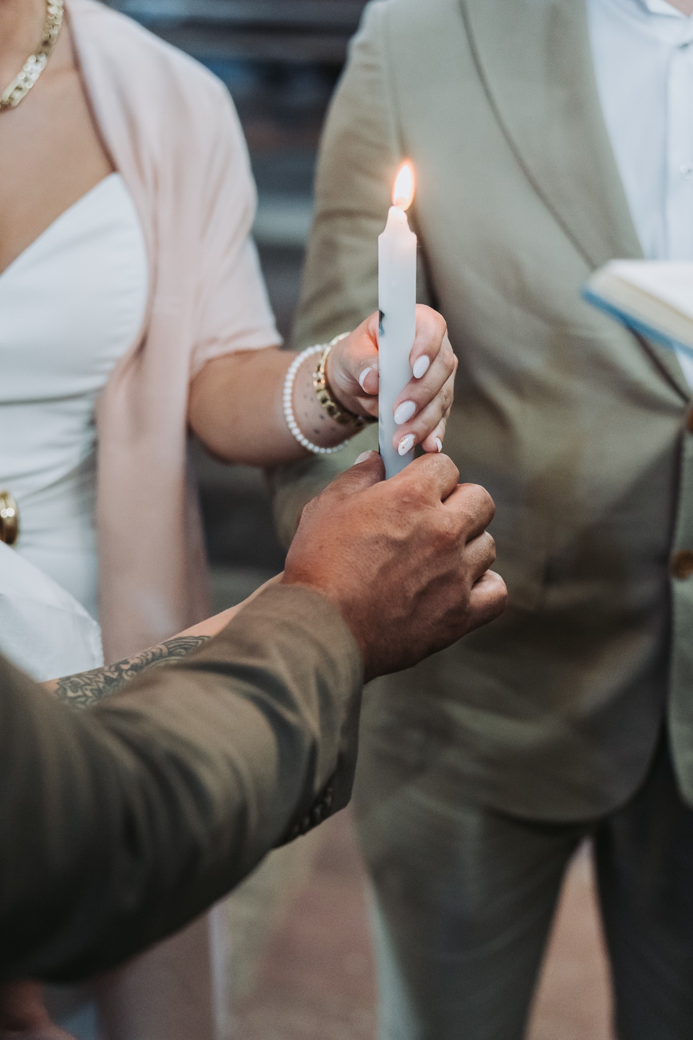 Le mani della famiglia con la candela accesa