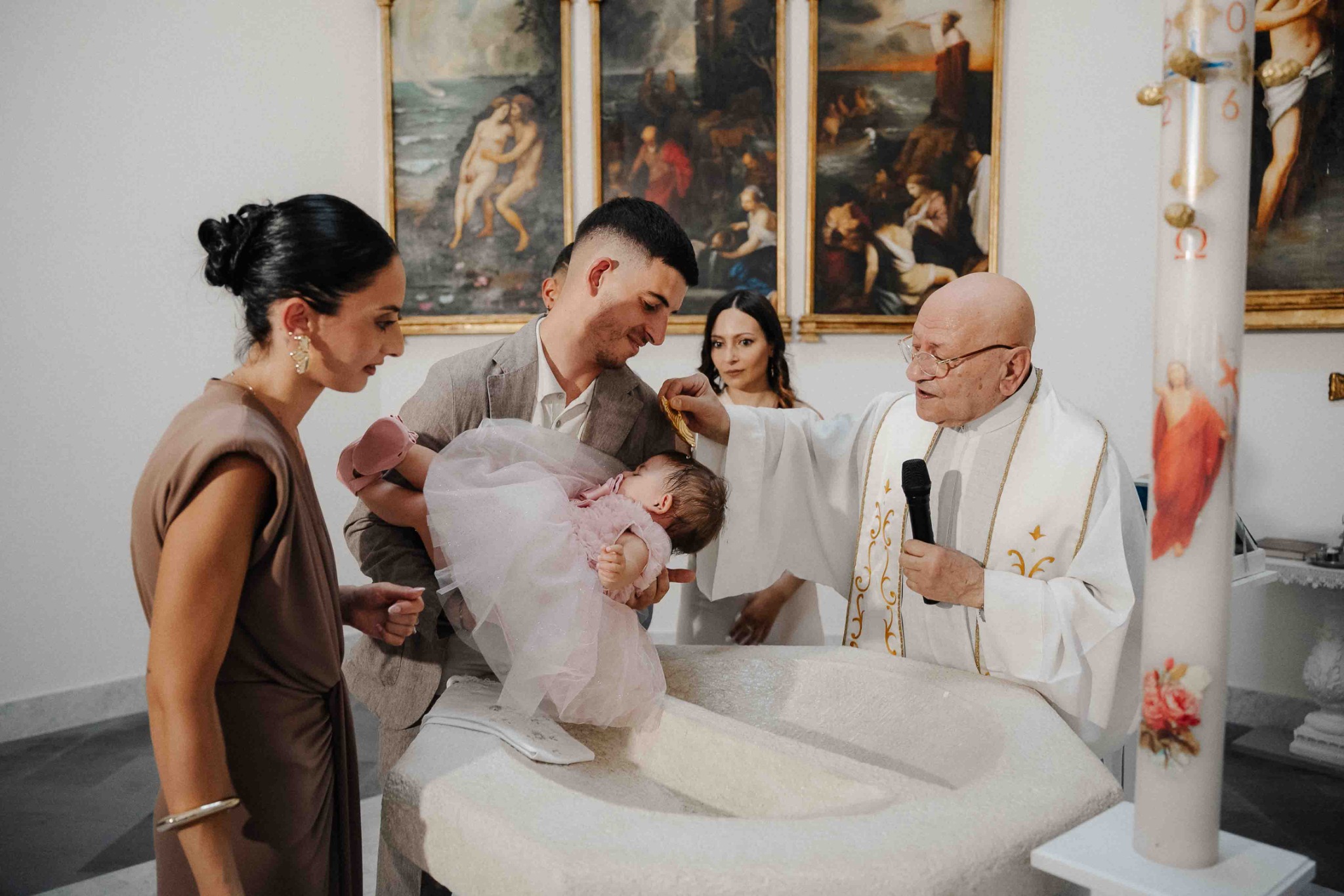 La famiglia accanto al fonte battesimale