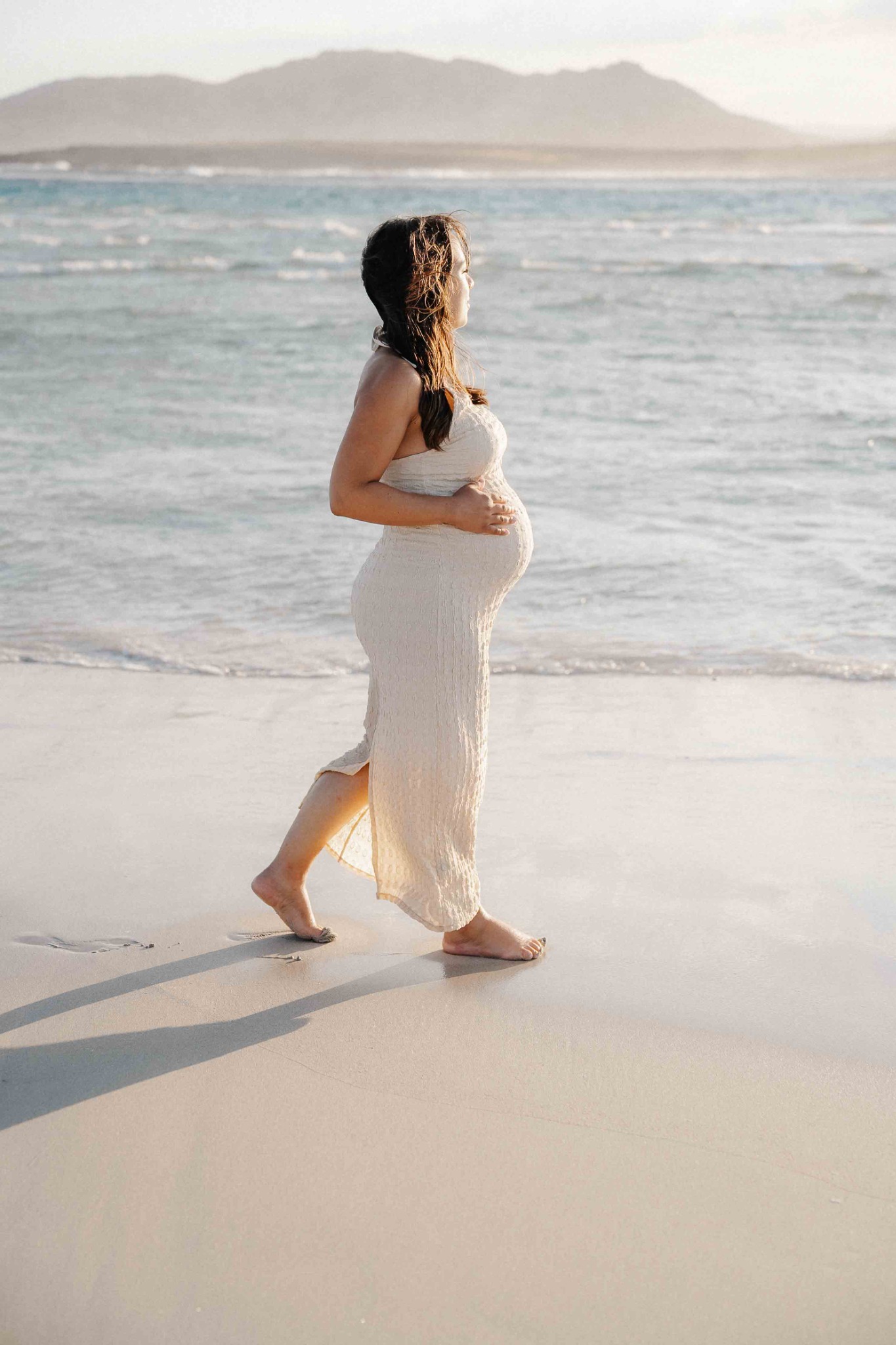 La futura mamma cammina sulla spiaggia